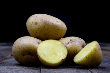 Tasty potatoes on a wooden table. Vegetables on the kitchen table in a jute sack.