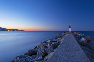 Picturesque sunset sea landscape with a lighthouse (Empuriabrava, Spain)