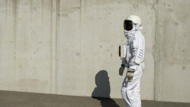 The cosmonaut walks around the city. An unusual scene from the city.
