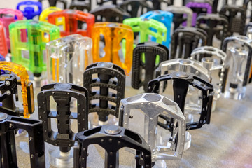 Many colorful bicycle pedals on store shelve.