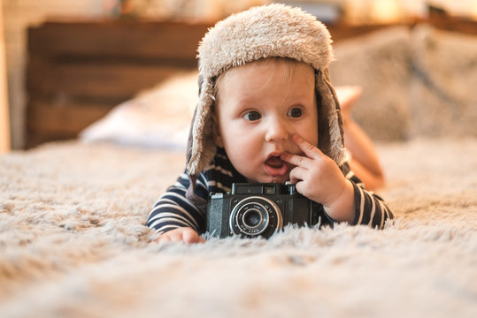 Portrait of a cute boy in hands with retro photo camera