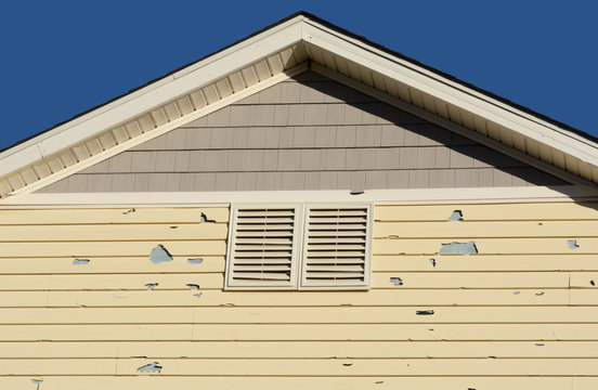 Holes in exterior siding in home from damage by hail storm 