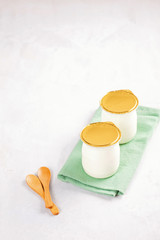 Fototapeta na wymiar Industrial natural yogurt in plastic cans. Healthy and fast breakfast concept