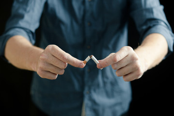 Man breaks a cigarette. Concept of no Smoking