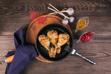 Fried chicken legs with sauces in pan
