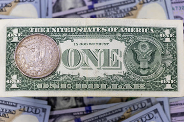 hundred dollar bills, background. on top of one dollar and one dollar silver.