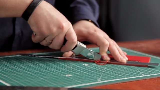 In the workshop, a man glues the workpieces of the skin, making a wallet