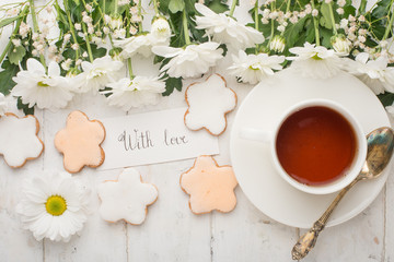 Tea with flowers and biscuits made with love. Top view with empty space for inscriptions