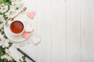 Tea with flowers and biscuits made with love. Top view with empty space for inscriptions