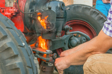 Traktor beim Vorglühen und starten mit offenem Feuer.