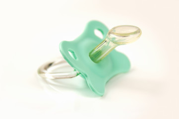 Green baby's pacifier isolated on white background