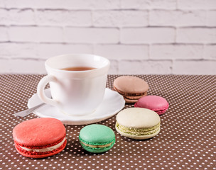 Cup of tea with colorful french macaron