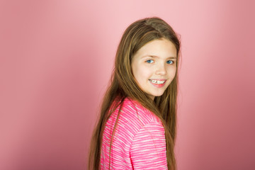 Fototapeta premium Little girl with long hair. Beauty and kid fashion with cosmetics and healthy hair. Hairdresser, skincare, casual style, denim. Stylish girl with pretty face on grey background.
