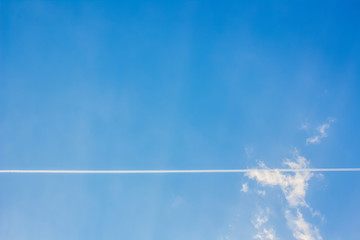 Blue sly with clouds and airplane line