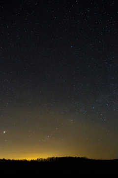 Stars of the Milky Way in the night sky. A view of the starry space background sunset illuminated the horizon.