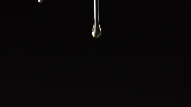 Drops of Honey Fall and Reform on Black