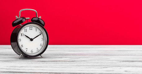 alarm clock on a color background on a wooden board
