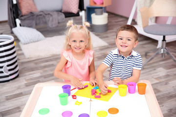 Fototapeta premium Cute little children modeling from playdough at home