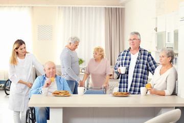 Senior people having breakfast at care home