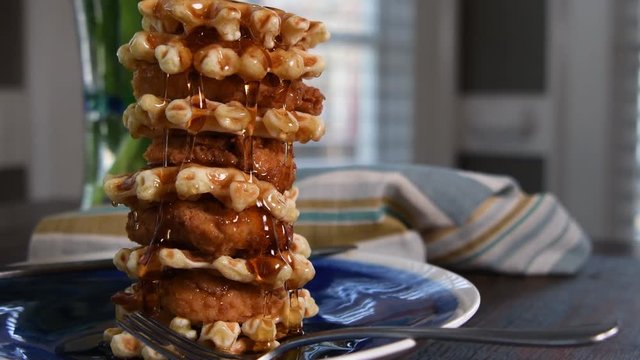 Pouring Too Much Syrup Over Stack of Chicken and Waffles