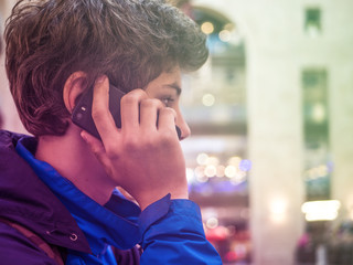 young teenager with phone in the jacket close up portrait in the city