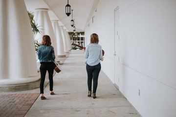 Pretty Female Musicians Walking Down Outdoor Corridor