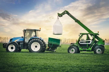 Poster fertilizers are carried in a sacks on the tractor trailer in the field in the spring © Porokhniak Valentyn
