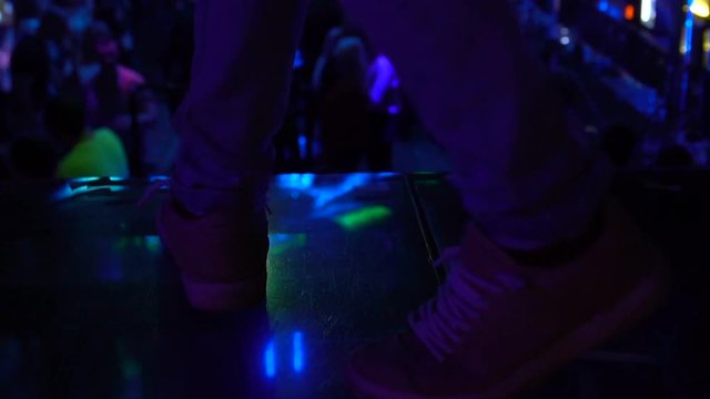 Male legs on night club stage, mc entertaining audience, party celebration