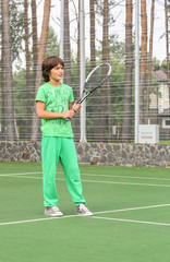 handsome boy in green sports suit, playing tennis