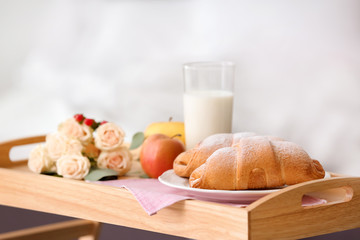 Tray with delicious croissants, milk and apples indoors