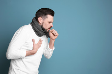 Mature man coughing on color background
