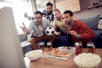 Fans of soccer watching match at home