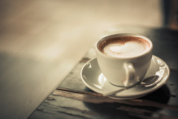 Closeup of a cup filled with espresso or latte on a coffee shop table