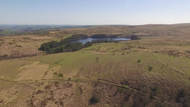 Aerial Drone Footage of Reservoir / Lake Surrounded by Trees & Moorland, UK Countryside