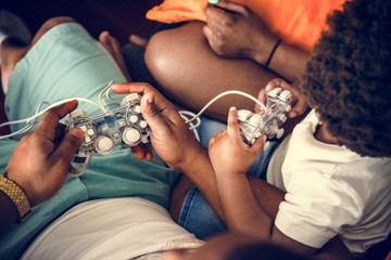 Black family playing game console together © Rawpixel.com