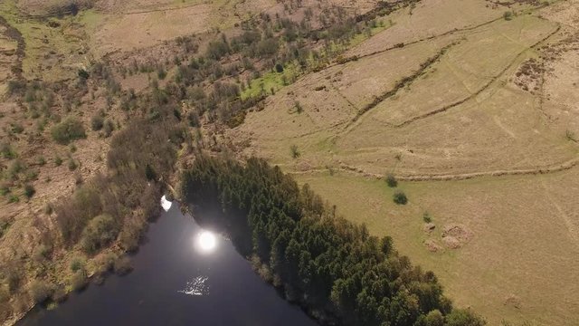 Aerial Drone Footage of Reservoir / Lake Surrounded by Trees & Moorland, UK Countryside