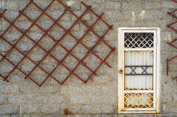 The old door is rusty in the concrete wall