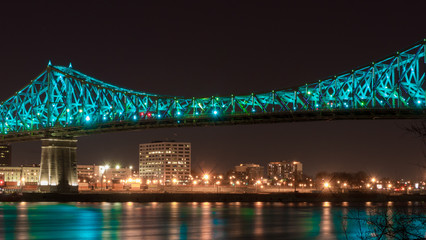 Long exposure shot of Jacques Cartier Bridge Illumination in Montreal, reflection in water. Montreal, Canada