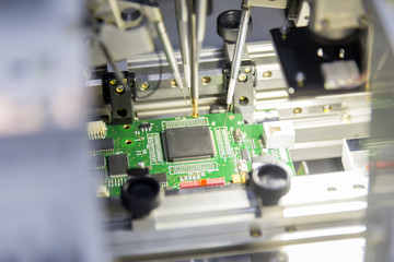 The microchip on the main board in the assembly line in the light blue scene with lighting effect,...