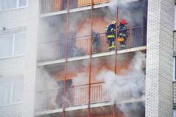 Russia, Saint-Petersburg - 28 march. High-rise condominium or apartment burning. Fire in apartments of a large tenement-house. Firefighters in gas masks rescue people from smoke and extinguish fire.