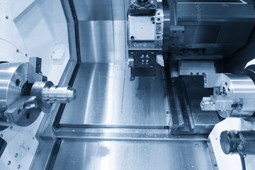 The CNC turning or lathe machine cutting the thread at the end of metal cone shape part in the light blue scene .High technology manufacturing process.