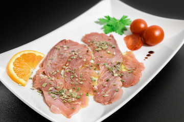 A delicious fresh Mediterranean tuna carpaccio dressed with olive oil, chives, parsley and at drops of orange juice. 