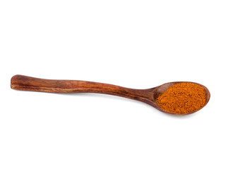 Dark wood spoon with ground red pepper isolated on white background.