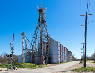 grain elevators next to a railroad crossing