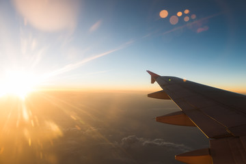 The plane is flying through the sunset sky