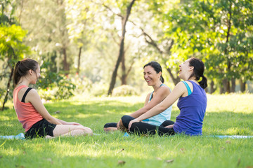 Activities in the family, mother and daughter relaxing in the park after practicing yoga.