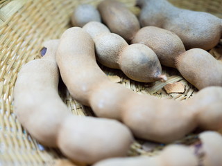 Close up sweet ripe tamarind pods in the basket