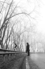 Traveler asian man with a long coat in foggy misty road