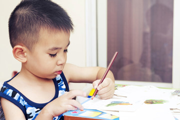 Smart Boy Writing Alphabet and Drawing Picture with Color Pencil on Kid Card