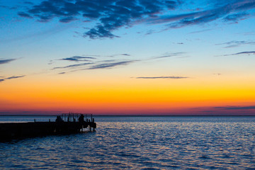Fototapeta na wymiar fisherman in orange sunset light, outline shot